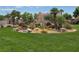 Lush greenbelt with mature trees, colorful flowering plants and decorative boulder accents at 412 Orchid Oasis Ave, North Las Vegas, NV 89031