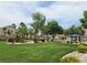 Community greenbelt with flowering plants, mature trees and manicured lawn at 412 Orchid Oasis Ave, North Las Vegas, NV 89031