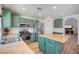 Charming kitchen with stainless steel appliances, green cabinets, and center island at 412 Orchid Oasis Ave, North Las Vegas, NV 89031