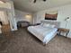 Spacious main bedroom boasts soft carpet, neutral paint, and a cozy seating area, creating a relaxing retreat at 412 Orchid Oasis Ave, North Las Vegas, NV 89031