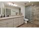 Bathroom featuring dual sinks, quartz counters, shower with glass blocks, and neutral colors at 4219 E Pinecrest Cir, Las Vegas, NV 89121