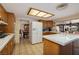 Classic kitchen with wood cabinetry, tile countertops, and an island, seamlessly connecting to the backyard and dining area at 4219 E Pinecrest Cir, Las Vegas, NV 89121