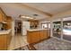 Bright kitchen features tile countertops, oak cabinets, and a breakfast bar overlooking the pool at 4219 E Pinecrest Cir, Las Vegas, NV 89121