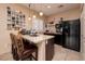 Modern kitchen features an island with barstool seating, stainless steel appliances and a black refrigerator at 4219 E Pinecrest Cir, Las Vegas, NV 89121