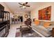 Inviting living room featuring tile floors, ceiling fan, breakfast bar, and a comfortable sofa with orange pillows at 4219 E Pinecrest Cir, Las Vegas, NV 89121