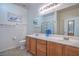Well-lit bathroom with double sink vanity, large mirror, and glass-enclosed shower at 4725 Basilicata Ln # 204, North Las Vegas, NV 89084