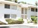 Clean exterior of a two-story unit featuring white siding, a small front yard with mature shrubs, and dual entry doors at 4770 Topaz St # 113, Las Vegas, NV 89121