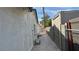 Narrow side yard with a concrete path and block fence at 5239 Treasure Ave, Las Vegas, NV 89122