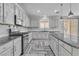 Modern kitchen featuring granite countertops, herringbone floors, and stainless steel appliances at 5425 Pride Mountain St, North Las Vegas, NV 89031