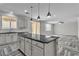Bright kitchen with granite countertops, island with breakfast bar, and herringbone-patterned flooring at 5425 Pride Mountain St, North Las Vegas, NV 89031