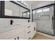 Modern bathroom with double vanity, large mirror, and glass enclosed shower with tile accents at 56 Belle Ridge Ave, Las Vegas, NV 89123
