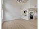 Bright living room with kitchen view, wood floors, and soaring ceilings creating an open concept space at 56 Belle Ridge Ave, Las Vegas, NV 89123