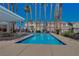 Community pool with palm trees and seating area for residents to enjoy at 56 Belle Ridge Ave, Las Vegas, NV 89123