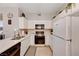Clean kitchen with white cabinets and appliances, a tile backsplash, and ample counter space at 5751 E Hacienda Ave # 154, Las Vegas, NV 89122