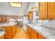 Functional kitchen featuring tile countertops, wooden cabinetry, and a view of the breakfast nook at 6508 Peppermill Dr, Las Vegas, NV 89146