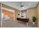 Bright office space featuring a ceiling fan, neutral carpet, and a simple desk with plants at 6508 Peppermill Dr, Las Vegas, NV 89146
