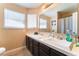 Bathroom with dual sinks, dark wood vanity, and a large framed mirror at 6529 Hartwood Rd, Las Vegas, NV 89108