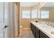 Spacious bathroom featuring dual sinks and a shower with a curtain at 6529 Hartwood Rd, Las Vegas, NV 89108