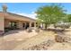 A large backyard features a spacious patio, desert landscaping, and a built-in grill for outdoor entertaining at 6841 Longmeadow Dr, Pahrump, NV 89061