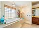 Bright bathroom with a soaking tub, separate shower, and window with a privacy screen offering a spa-like experience at 6841 Longmeadow Dr, Pahrump, NV 89061