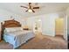 Spacious bedroom featuring a grand wooden headboard, soft lighting, and archway leading into the bathroom at 6841 Longmeadow Dr, Pahrump, NV 89061