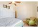 Cozy bedroom with carpet flooring, ceiling fan and a comfortable-looking green chair at 6841 Longmeadow Dr, Pahrump, NV 89061