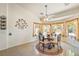 Bright breakfast nook with large windows, tile flooring, and decorative light fixture above round table at 6841 Longmeadow Dr, Pahrump, NV 89061