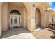 Home front porch with arched entry and columns, tile flooring, and sitting bench at 6841 Longmeadow Dr, Pahrump, NV 89061