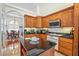 Kitchen features wood cabinets, tile backsplash, and adjacent breakfast area at 6841 Longmeadow Dr, Pahrump, NV 89061