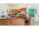 Spacious kitchen featuring wood cabinetry, stainless steel appliances and a breakfast bar with stools at 6841 Longmeadow Dr, Pahrump, NV 89061