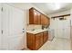 Functional laundry room features wood cabinets, a sink and a white utility closet at 6841 Longmeadow Dr, Pahrump, NV 89061