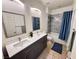 Bright bathroom featuring a double vanity, well-lit mirror, and a shower with a bathtub at 7035 Thistle Ridge St, Las Vegas, NV 89166