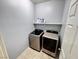 Modern laundry room featuring a washer, a dryer, and a shelf for storing laundry detergent at 7035 Thistle Ridge St, Las Vegas, NV 89166