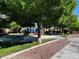 Community playground featuring a colorful play structure and mature trees for shade at 7035 Thistle Ridge St, Las Vegas, NV 89166