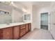 Well-lit bathroom featuring a double sink vanity, tiled floors, and a separate shower, creating a spa-like experience at 7465 Widewing Dr, North Las Vegas, NV 89084