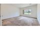 Large bedroom featuring a neutral color palette, carpet flooring, and a window providing natural light at 7465 Widewing Dr, North Las Vegas, NV 89084