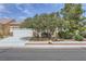 Well-manicured front yard with mature trees and shrubs complementing the home's exterior at 7465 Widewing Dr, North Las Vegas, NV 89084