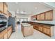Spacious kitchen with an island, stainless steel appliances, and wood cabinetry providing ample storage and functionality at 7465 Widewing Dr, North Las Vegas, NV 89084