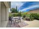 Charming backyard features a bistro set and lush tropical plants and trees at 7606 Grove Acre Ct, Las Vegas, NV 89131