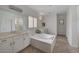 Bathroom featuring dual vanities, large soaking tub with jets, and decorative light fixtures at 7606 Grove Acre Ct, Las Vegas, NV 89131