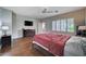 This bedroom features hardwood floors, neutral colored walls, a ceiling fan, and a large window at 7606 Grove Acre Ct, Las Vegas, NV 89131