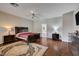This bedroom boasts neutral walls, a ceiling fan, dark furniture, and hardwood floors at 7606 Grove Acre Ct, Las Vegas, NV 89131
