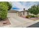 View of single story home featuring desert landscaping, a large driveway, and a two-car garage at 7606 Grove Acre Ct, Las Vegas, NV 89131