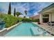 Backyard swimming pool with patio seating, mature hedges and tropical plants at 7606 Grove Acre Ct, Las Vegas, NV 89131