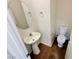 Cozy bathroom with a pedestal sink, oval mirror, and toilet with dark tile flooring at 7815 Shingle Beach St, Las Vegas, NV 89166
