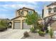 Two-story home with neutral siding, desert landscaping, two-car garage and a tile roof at 7815 Shingle Beach St, Las Vegas, NV 89166