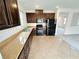 Kitchen featuring granite countertops, wood cabinets, black appliances, and tile flooring at 7815 Shingle Beach St, Las Vegas, NV 89166