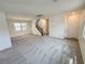 Spacious living room featuring neutral walls, carpet flooring, with stairs and front door access at 7815 Shingle Beach St, Las Vegas, NV 89166