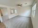 Bright living room featuring neutral carpet, a ceiling fan, and natural light from multiple windows at 7815 Shingle Beach St, Las Vegas, NV 89166