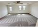 Spacious, carpeted bonus room with three large windows providing natural light and a ceiling fan at 7815 Shingle Beach St, Las Vegas, NV 89166